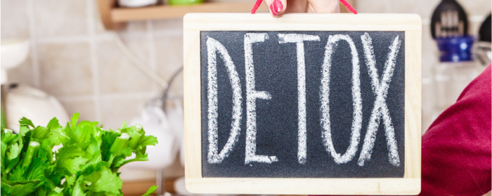 hand holding sign that says "detox"