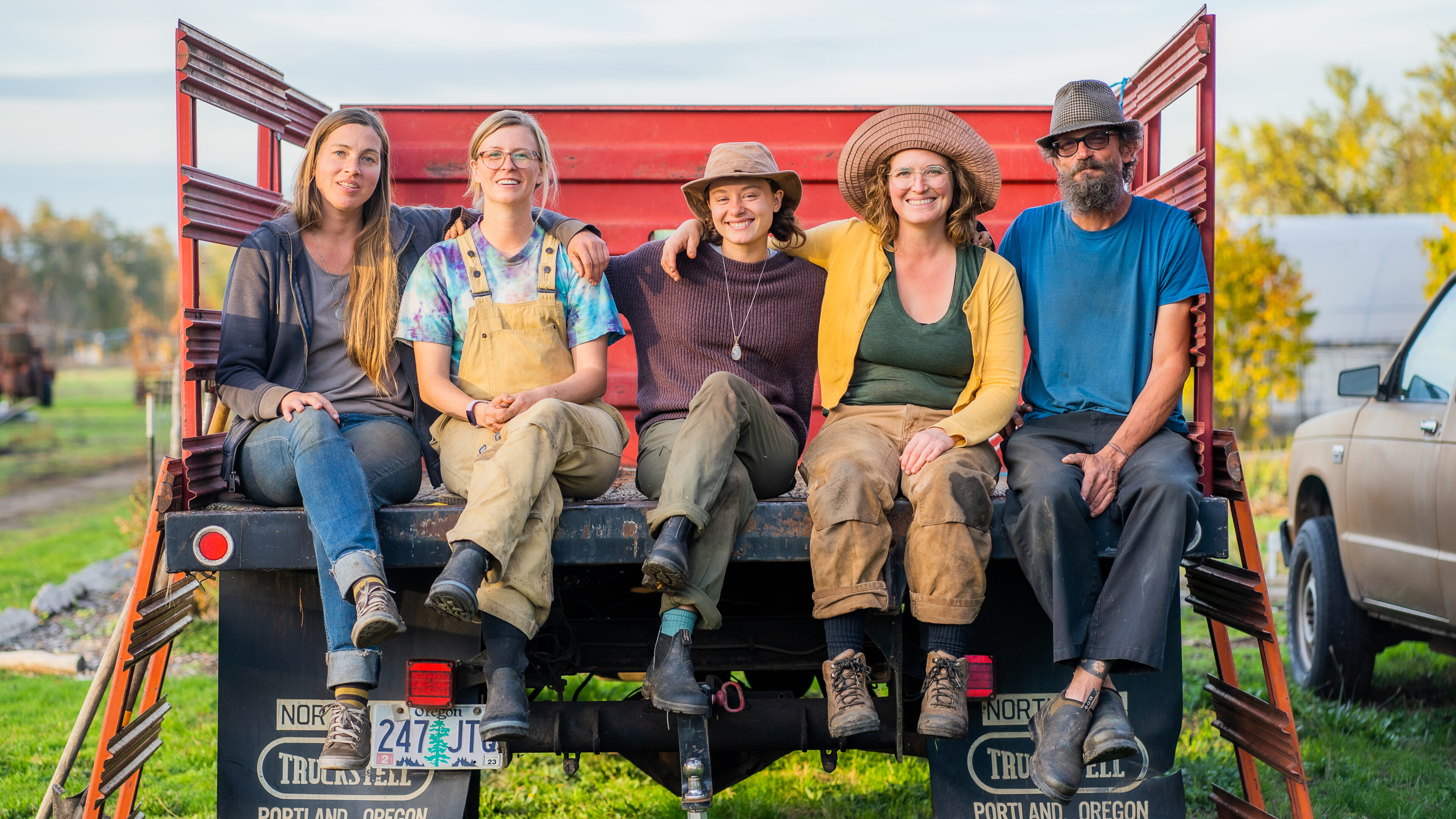 group of farmers sitting on the back of a truck